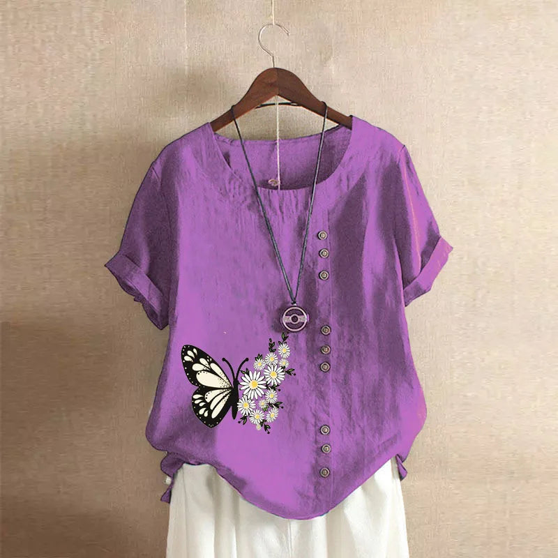Purple shirt with butterfly and flower design on a hanger against a beige wall