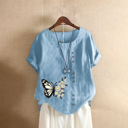 Light blue shirt with butterfly and flower design on a beige background