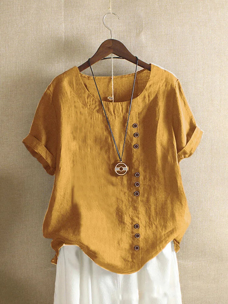 Yellow shirt with buttons on a hanger against a beige wall