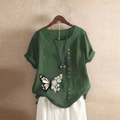 Green shirt with butterfly design on a hanger against a beige wall