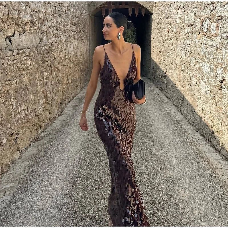 Woman in a patterned dress walking down a stone path.