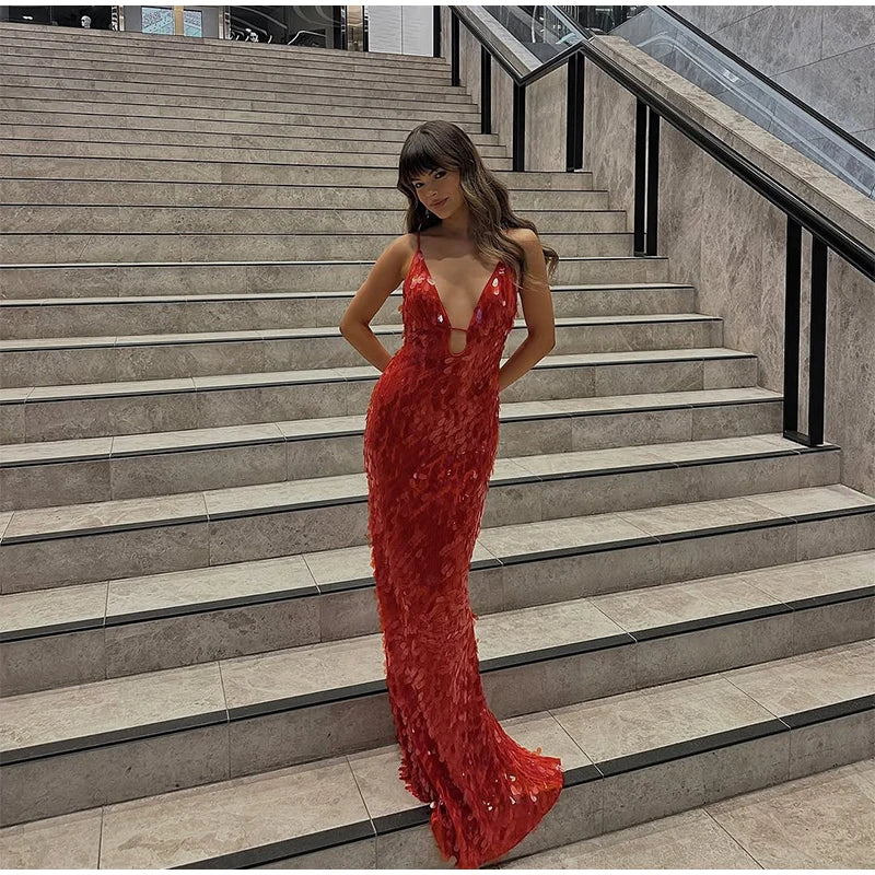 Woman in a red evening gown standing on stone steps.