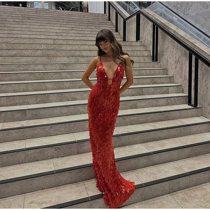 Woman in a red evening gown standing on stone steps.