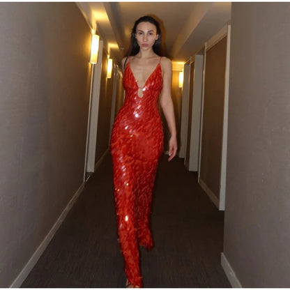 Woman in a red sequin dress walking down a dimly lit hallway.