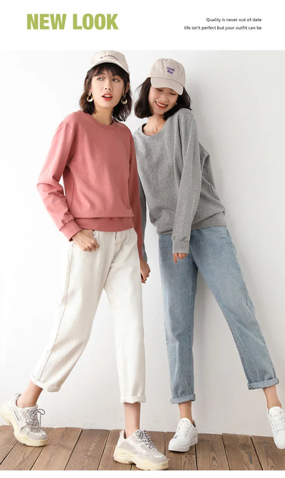 Two women wearing casual outfits with hats against a white background