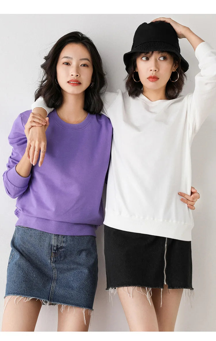 Two women wearing colorful outfits against a plain background