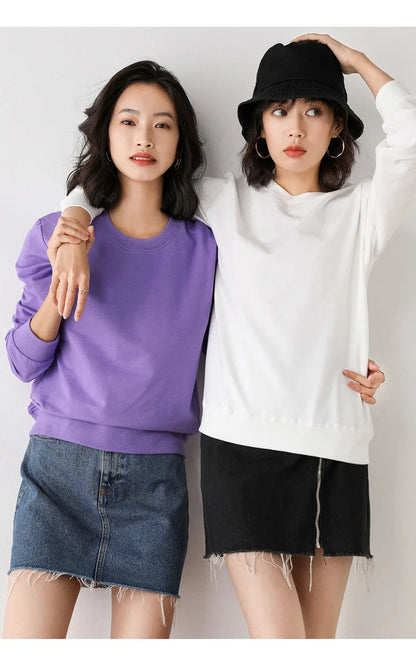 Two women wearing colorful outfits against a plain background