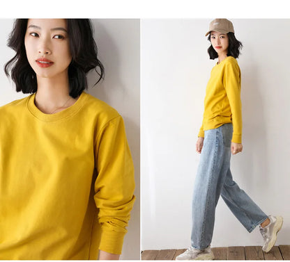 Woman wearing a yellow sweater and blue jeans against a white background