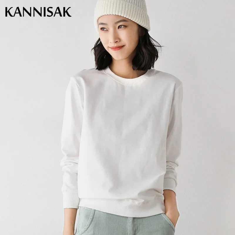 Person wearing a white sweater and light-colored pants on a plain background with 'KANNISAK' branding.