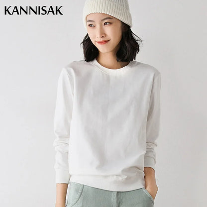 Person wearing a white sweater and light-colored pants on a plain background with 'KANNISAK' branding.