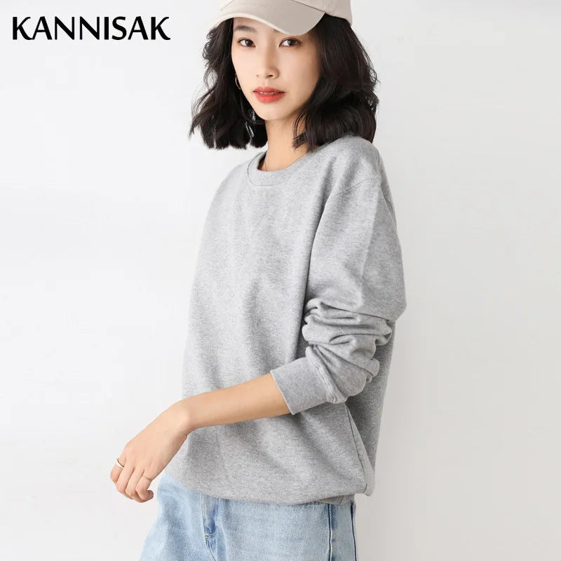 Woman wearing a gray sweater and light blue jeans on a white background with 'KANNISAK' branding.