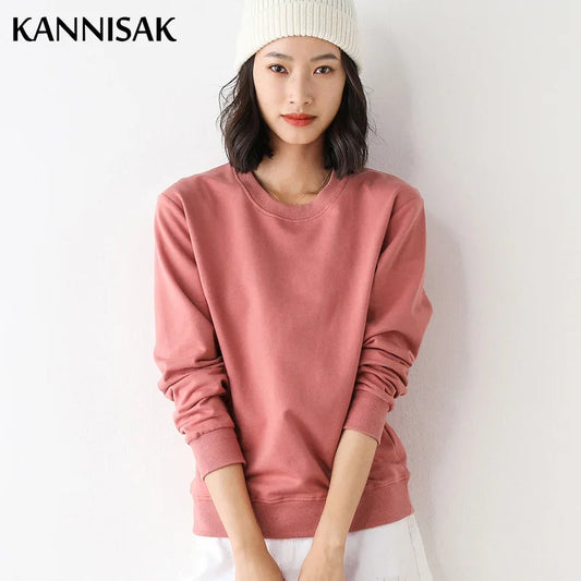 Person wearing a pink sweatshirt and white beanie against a plain background with 'KANNISAK' branding.