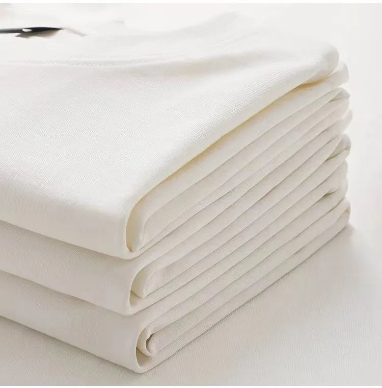 Stack of white folded sheets on a light background