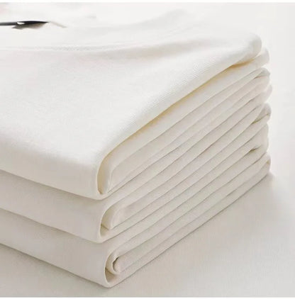 Stack of white folded sheets on a light background