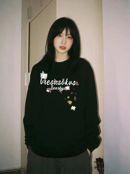 Person wearing a black sweatshirt with text and graphics in a room.