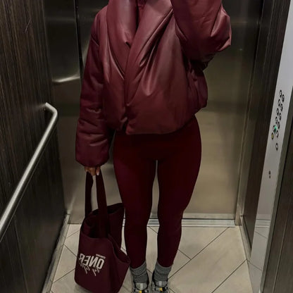 Person wearing a maroon outfit with a bag in an elevator