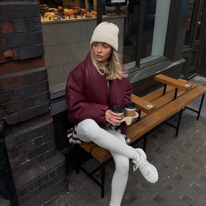 Person sitting on a bench holding coffee cups in an urban setting