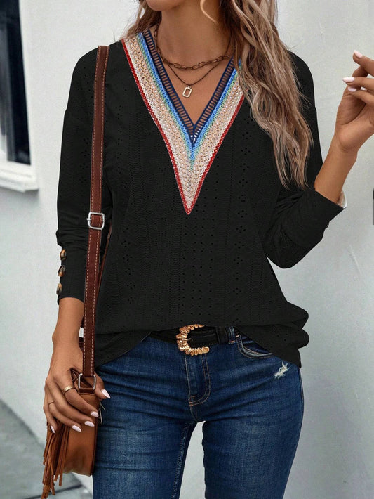 Woman wearing the evlira black lace patchwork long sleeve t-shirt with blue jeans