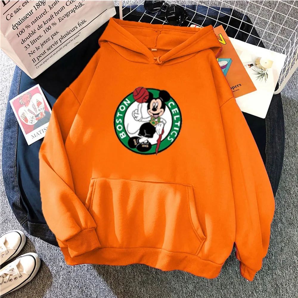 Orange hoodie with Boston Celtics logo on a surface with books and shoes.