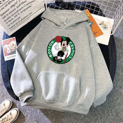 Gray hoodie with Boston Celtics logo on a surface with books and shoes.