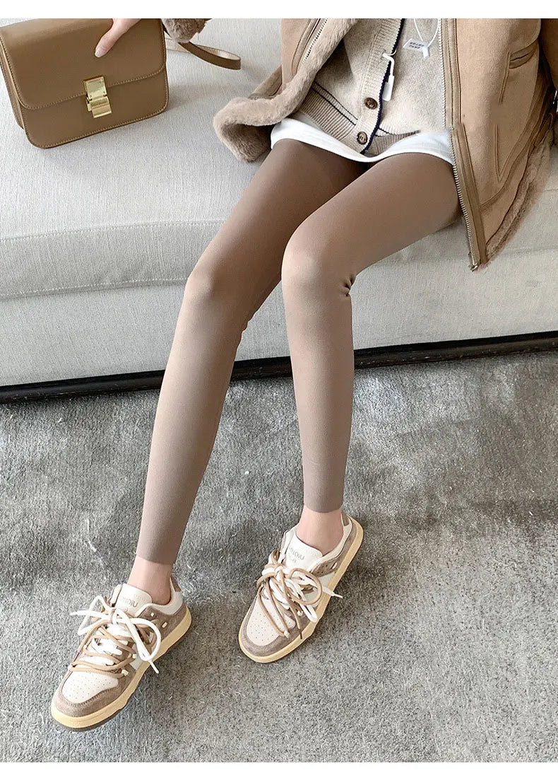 Person wearing beige tights and sneakers on a neutral background