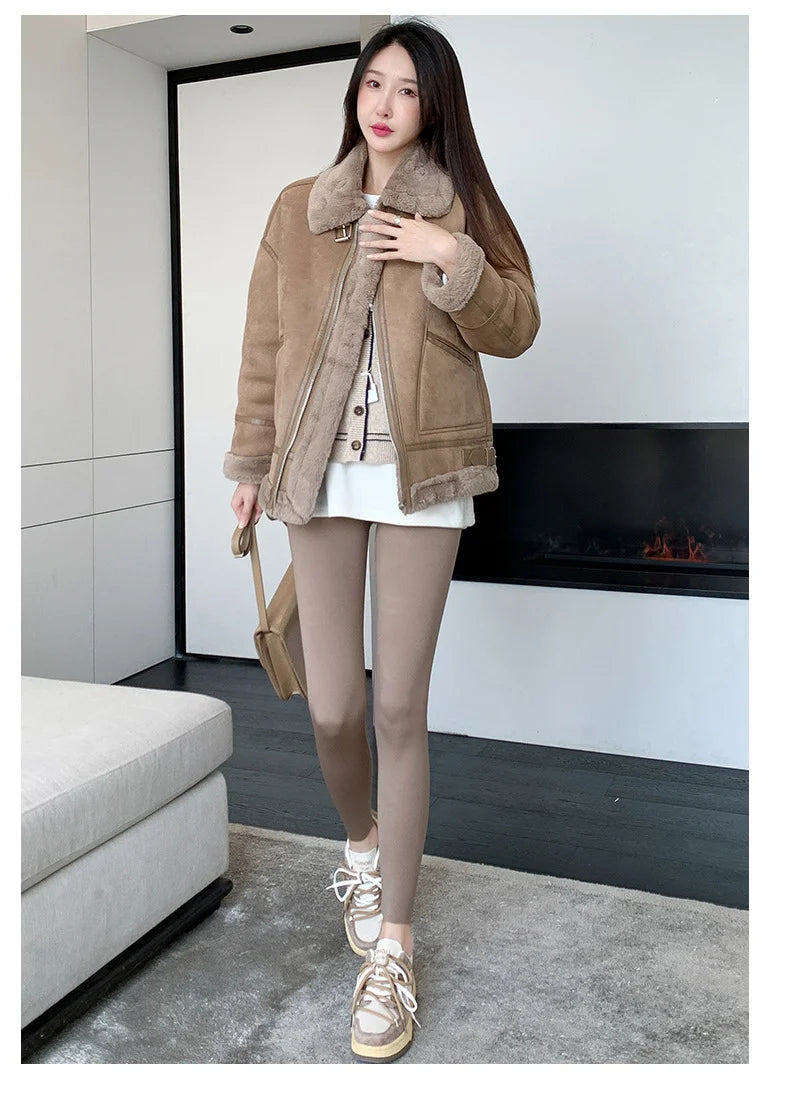 Woman wearing a brown shearling jacket in a modern living room.