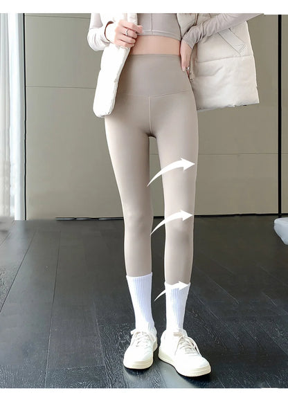 Person wearing beige leggings with white socks and shoes in a minimal indoor setting