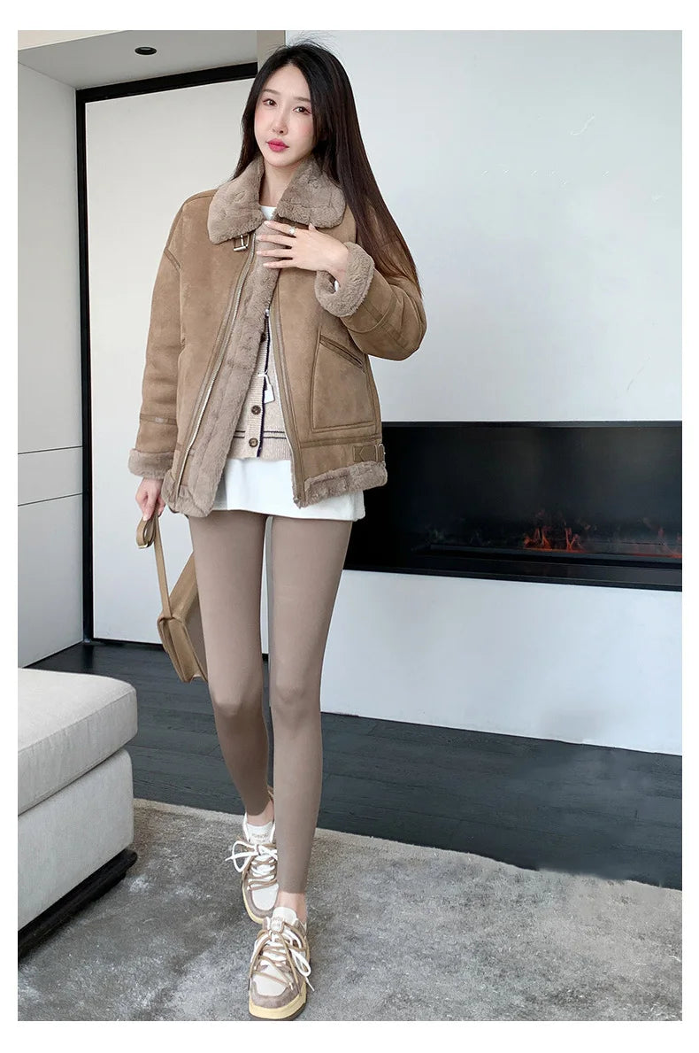 Woman wearing a brown shearling jacket in a modern living room.