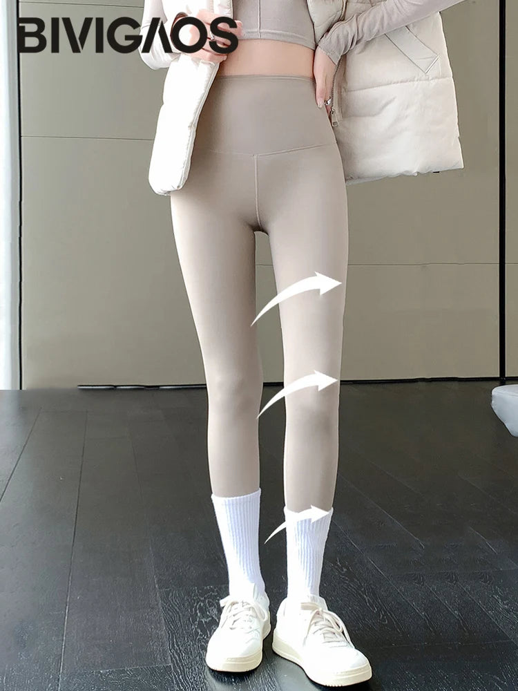 Person wearing beige leggings with a neutral background