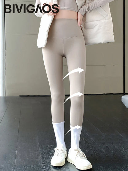 Person wearing beige leggings with a neutral background