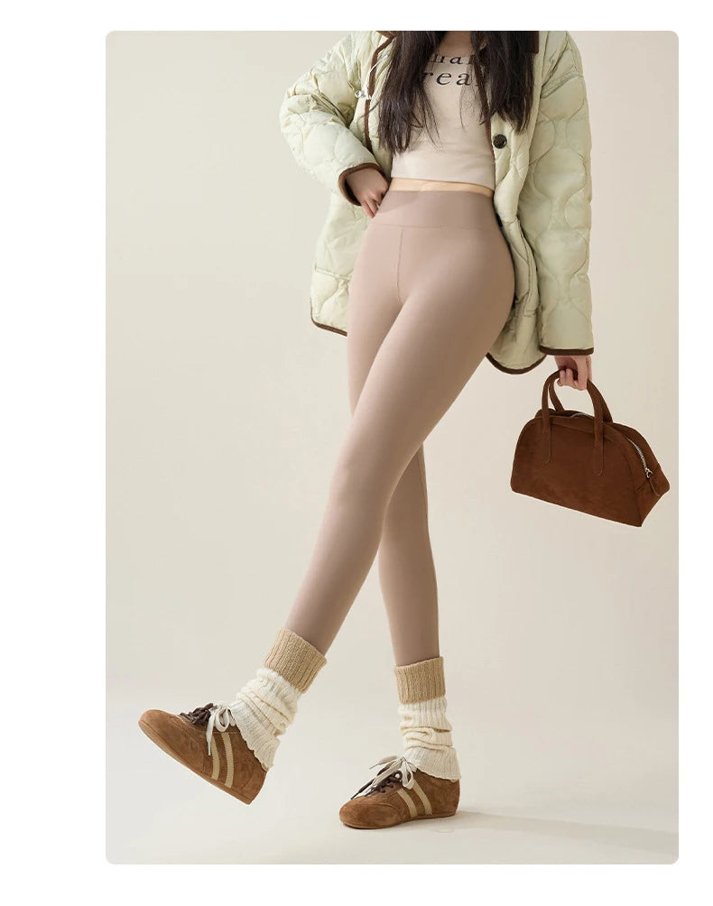 Person wearing beige leggings, a light green puffer jacket, and brown shoes on a plain background