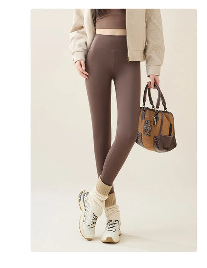 Person wearing brown leggings holding a brown handbag on a beige background