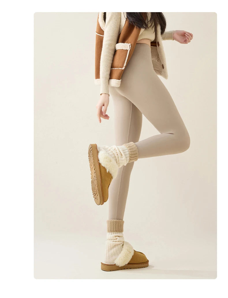 Person wearing beige leggings, brown shoes, and a light-colored jacket on a white background