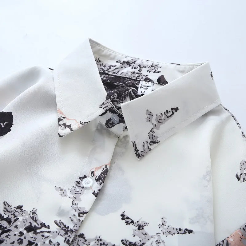 White shirt with black floral pattern on a light gray background