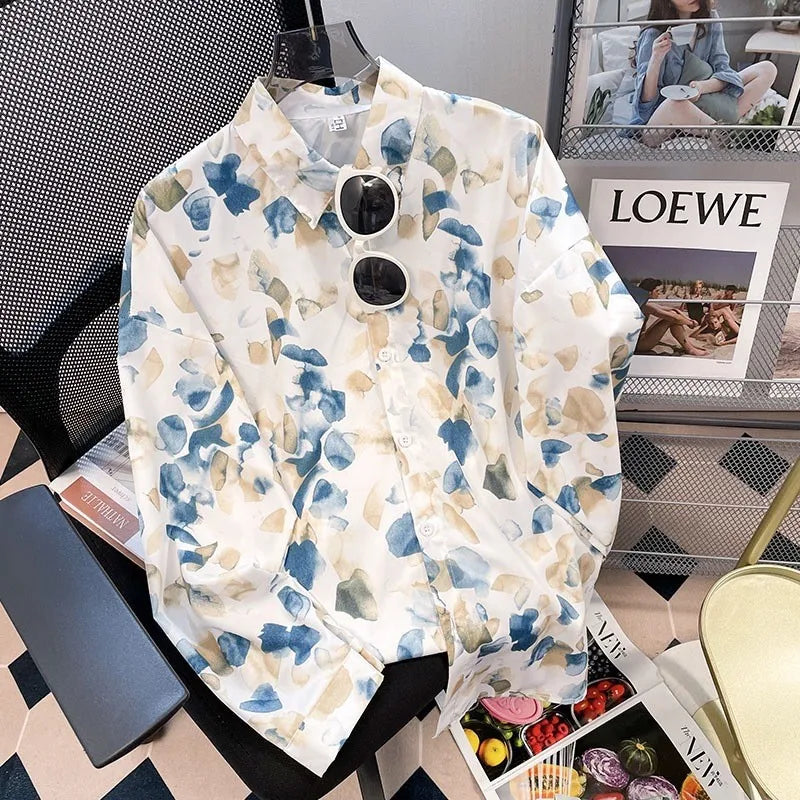 Floral shirt with sunglasses on a chair next to a magazine with 'LOEWE' branding.