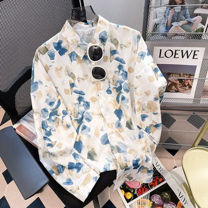 Floral shirt with sunglasses on a chair next to a magazine with 'LOEWE' branding.