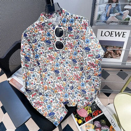 Floral-patterned jacket on a chair with a magazine and sunglasses in the background