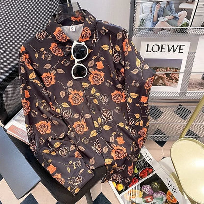 Floral-patterned shirt on a mannequin with sunglasses, placed on a surface with a magazine underneath.