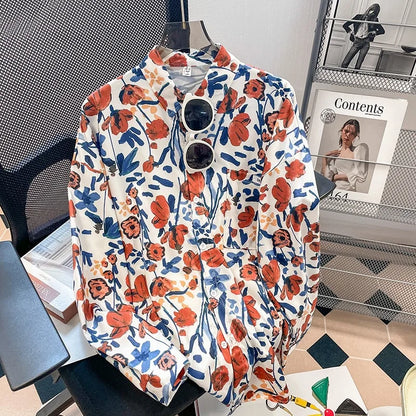 Floral patterned shirt on a hanger with sunglasses, placed on a surface.