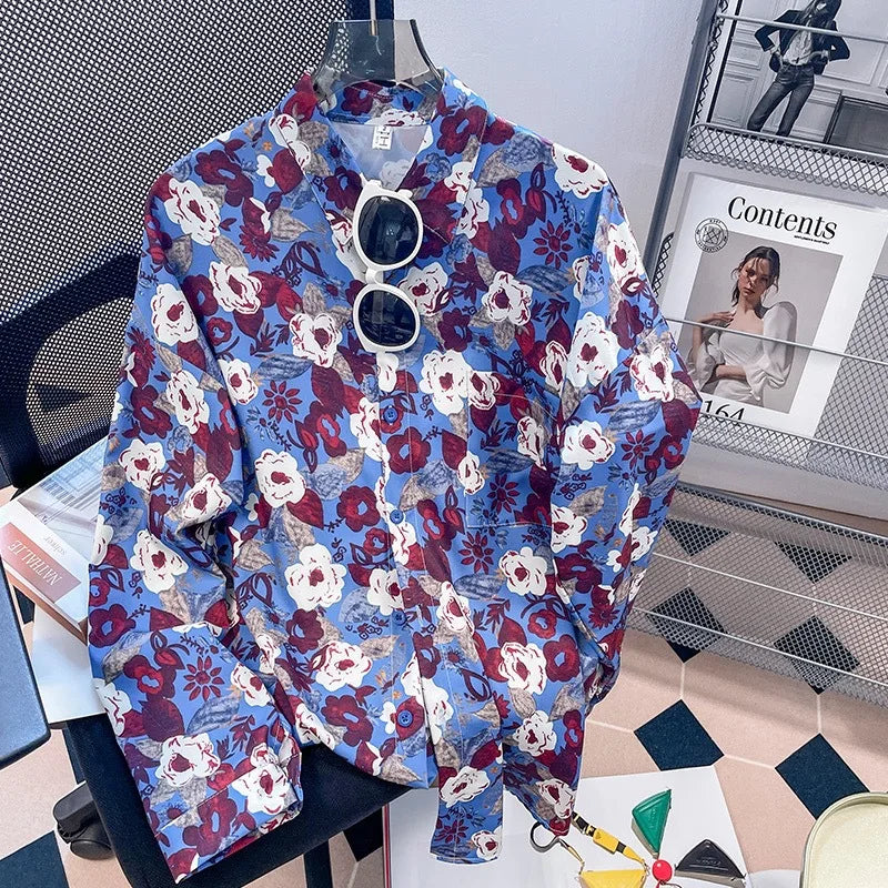 Floral patterned shirt on a hanger with sunglasses, placed on a surface with a magazine in the background.