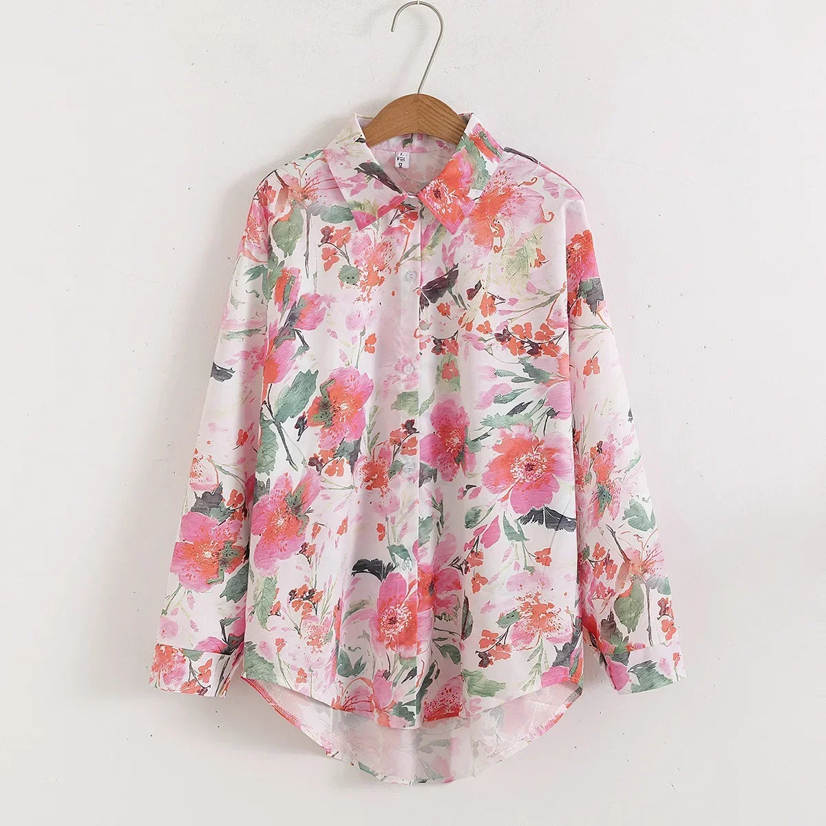 Floral patterned shirt on a hanger against a white background