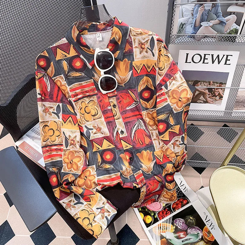 Colorful patterned shirt on a chair with sunglasses, surrounded by magazines including 'LOEWE'.