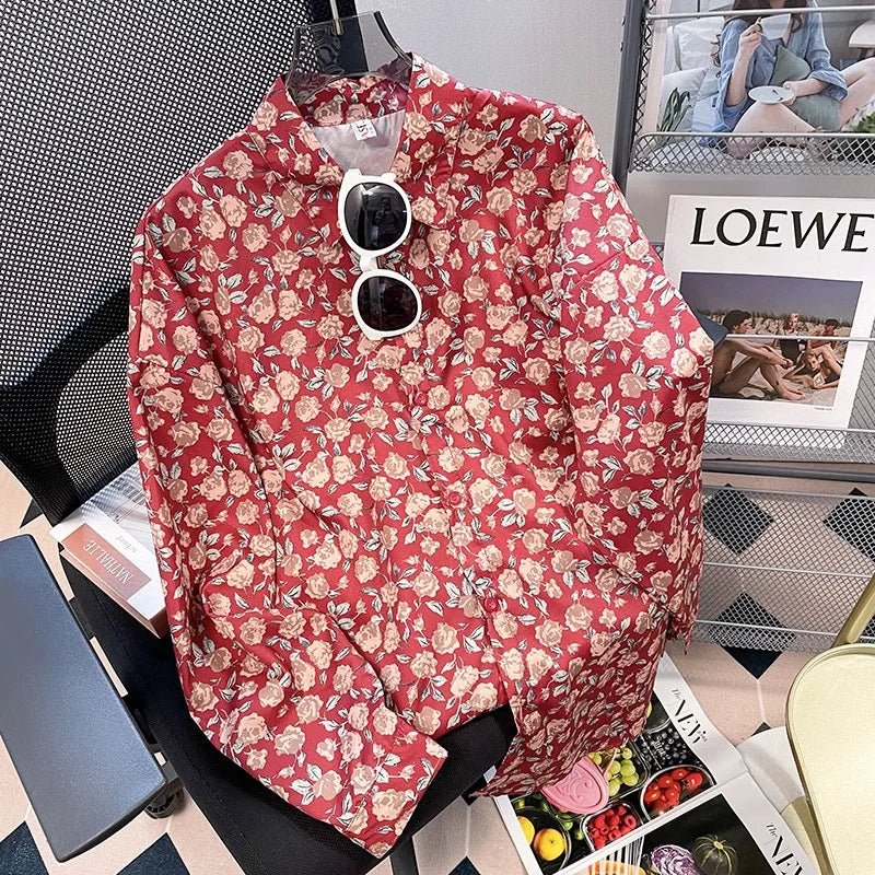 Red floral shirt with sunglasses on a hanger against a magazine background