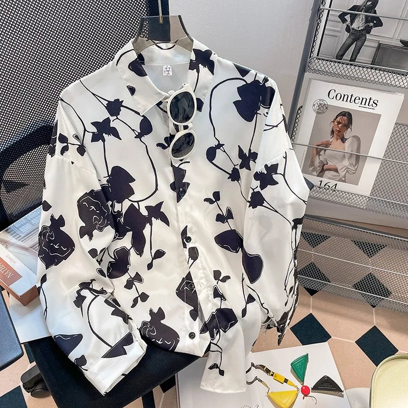 White shirt with black floral pattern on a hanger, with a magazine in the background.