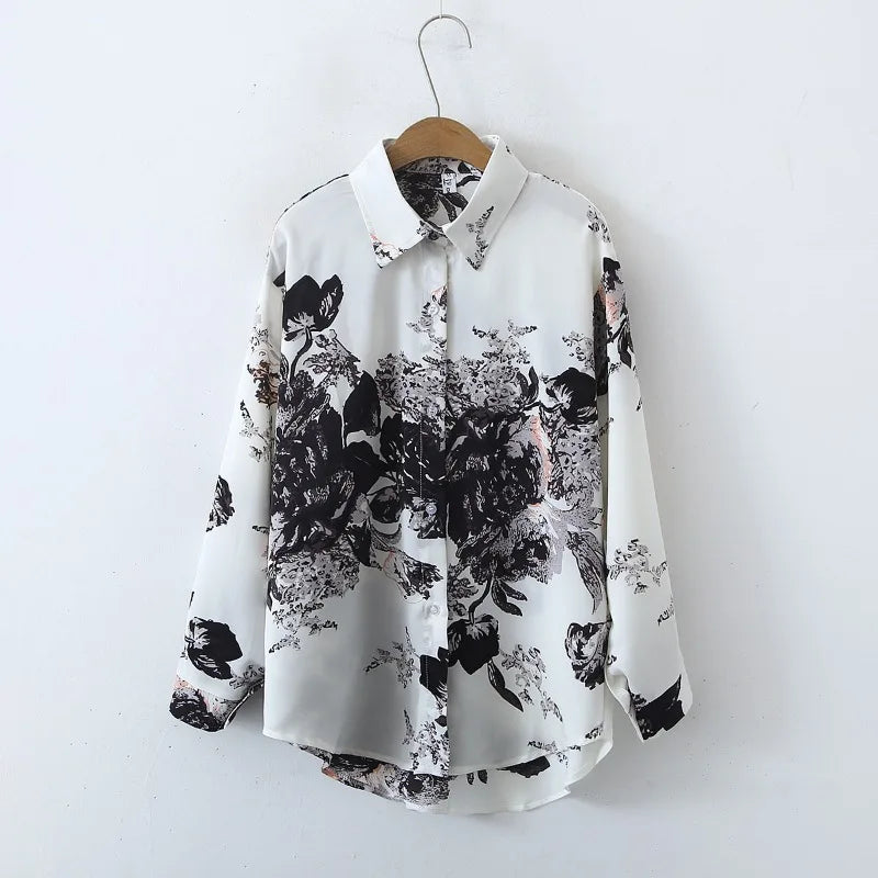 White shirt with black floral pattern on a wooden hanger against a white background