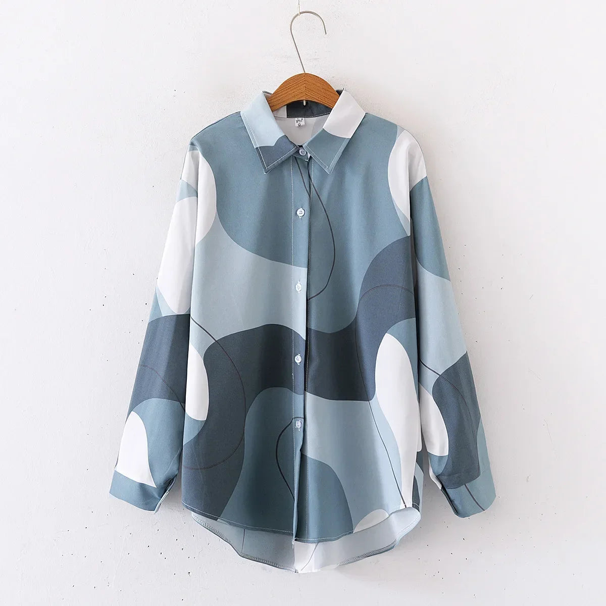 Blue and white patterned shirt on a hanger against a white background