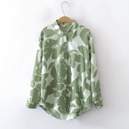 Green floral patterned shirt on a hanger against a white background