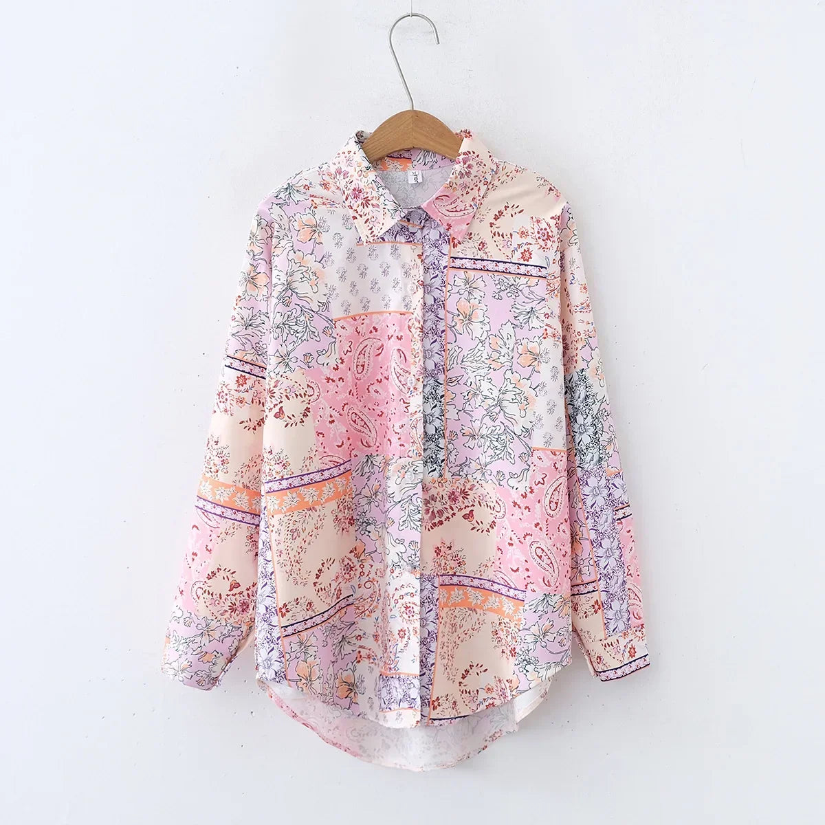 Floral patterned shirt on a hanger against a white background