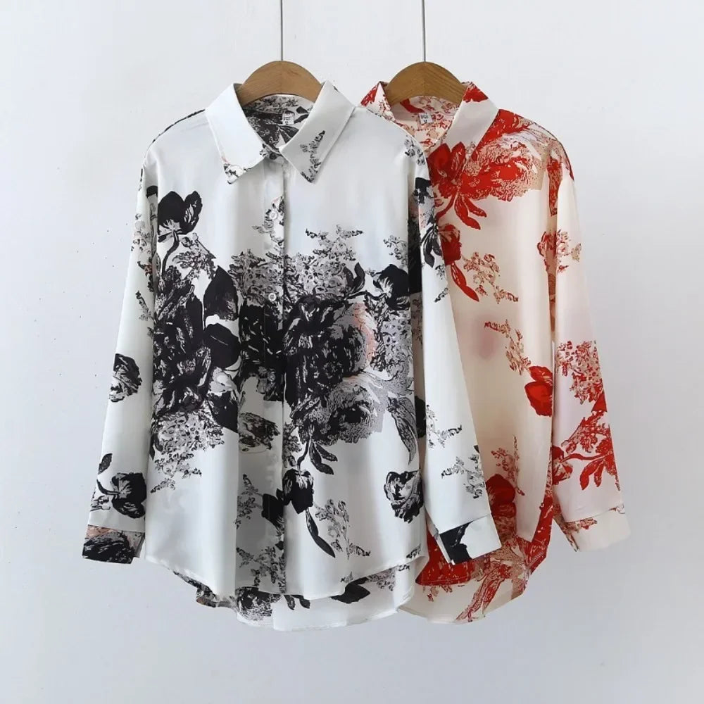 Two floral-patterned shirts on hangers against a white background