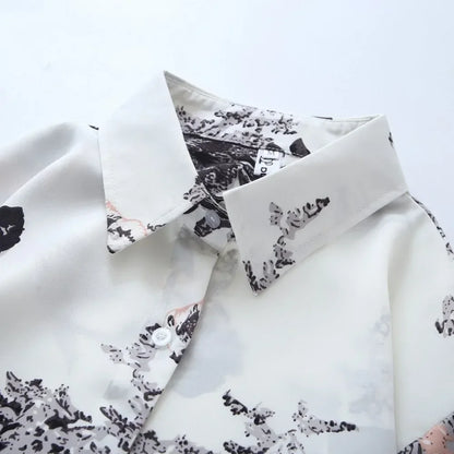 White shirt with black floral pattern on a light gray background